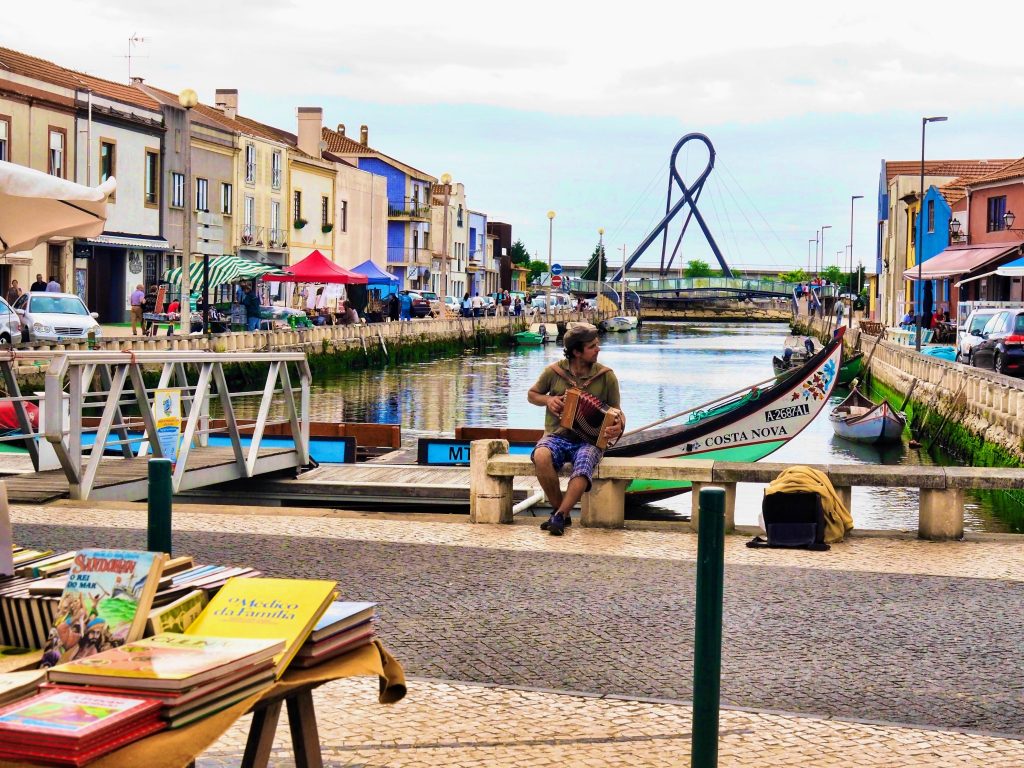 A side canal of Aveiro with a man handling an accordeon, Portugal.