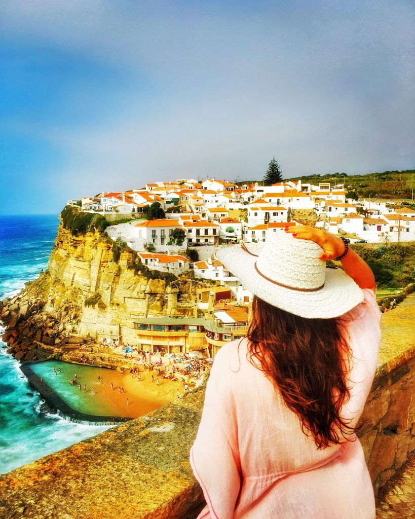 A girl looking at Azenhas do Mar prettu village. 